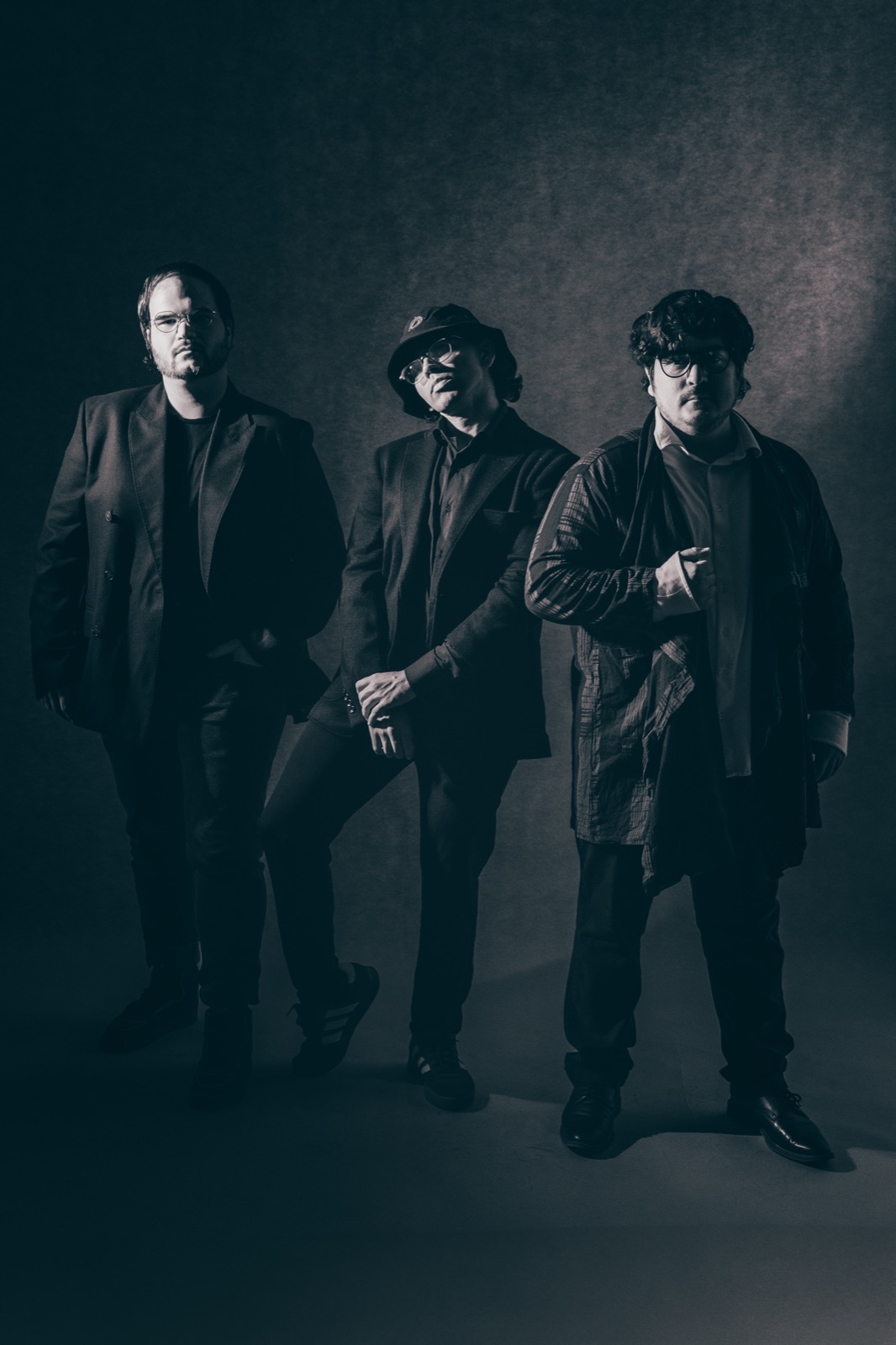 Xabier, Nox and R3M of Isekai Stage in a low-lit studio portrait